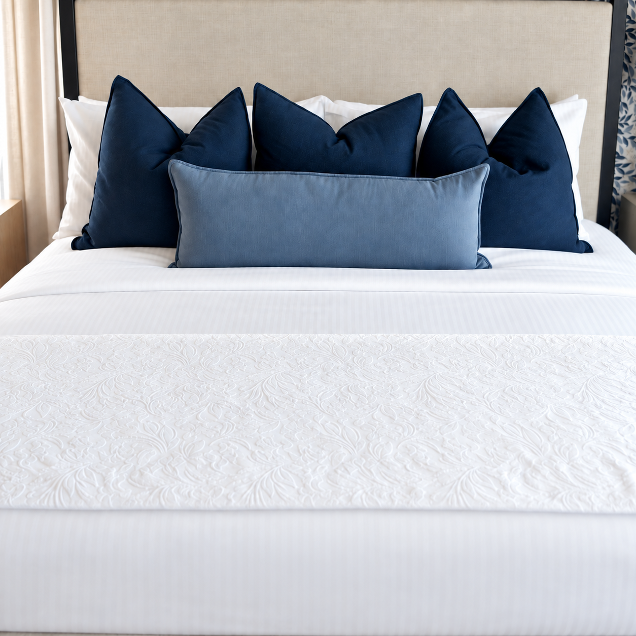 Elegant bedroom with blue floral wallpaper and cream upholstered bed