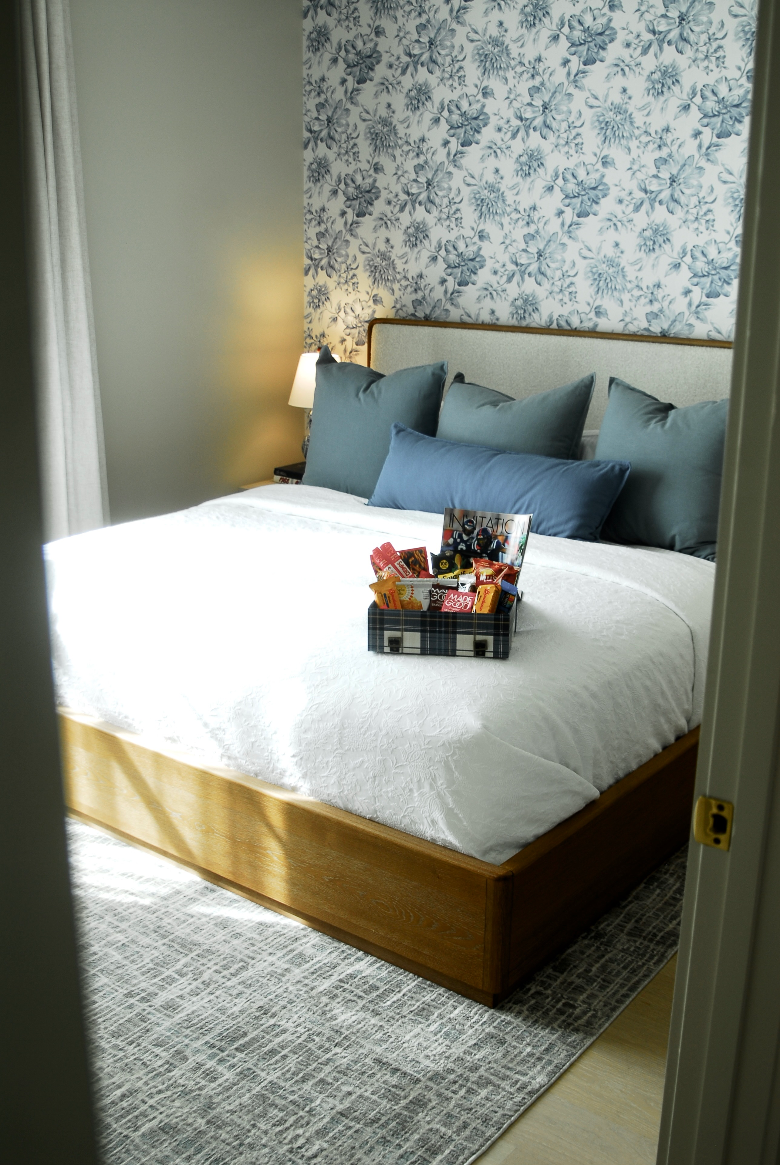 Elegant bedroom with blue lattice wallpaper and navy accent pillows